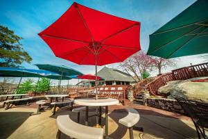 d'une terrasse avec des tables, des chaises et des parasols. dans l'établissement The Stone Castle Hotel & Conference Center, à Branson