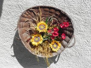 a basket with sunflowers and other flowers in it at Le Vieux Rascard Chambres d'Hotes in Champoluc