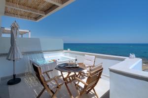 un tavolo e sedie su un balcone con vista sull'oceano di Pyrgos Beach Hotel Apartments a Mália