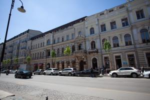 um grande edifício com carros estacionados ao lado de uma rua em Hotel Avenue 106 em Tbilisi