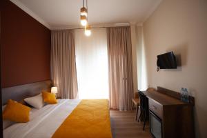 um quarto de hotel com uma cama e uma televisão em Hotel Avenue 106 em Tbilisi