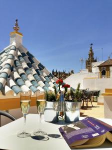 zwei Gläser Wein auf einem Tisch mit Dach in der Unterkunft Hotel Boutique Elvira Plaza in Sevilla