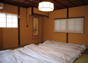 ein großes weißes Bett in einem Zimmer mit Fenster in der Unterkunft NARAigoto EENA HOUSE in Nara