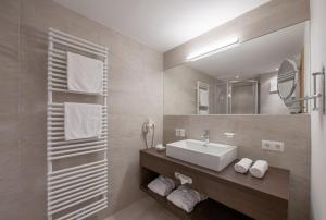 a bathroom with a sink and a mirror at Hotel Bergwelt in Längenfeld