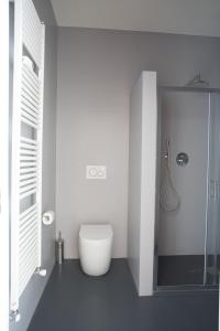 een witte badkamer met een toilet en een douche bij Rapanus Suites in Turijn