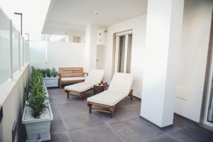 a balcony with white chairs and potted plants at Terradamare in Monopoli