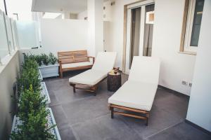 two white chairs on a balcony with plants at Terradamare in Monopoli