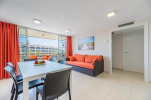 sala de estar con mesa y sofá en Rentalmar Navarra family suites, en Salou