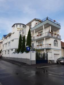 un bâtiment blanc avec des arbres sur son côté dans l'établissement Pensiunea Leo, à Braşov