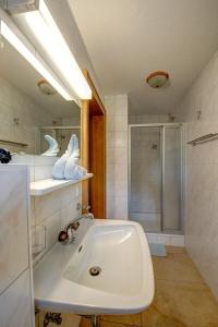 bagno bianco con lavandino e doccia di Jennys Huamatl a Serfaus