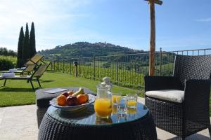 un tavolo con un cesto di frutta e bicchieri di succo d'arancia di The Grapevine by MANVI a Montepulciano