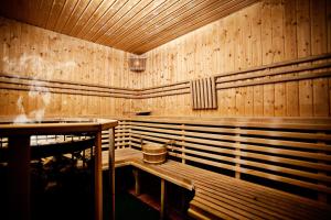 a room with wooden benches in a restaurant at Villa Centrum Młodości in Augustów