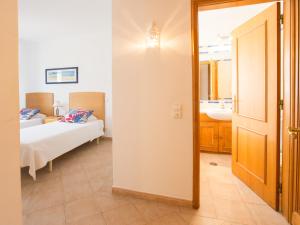 a bedroom with a bed and a bathroom with a mirror at Apartamentos Quinta da Praia in Alvor