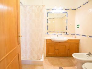 a bathroom with a sink and a toilet and a mirror at Apartamentos Quinta da Praia in Alvor