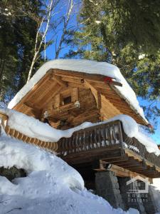 una baita di tronchi con tetto ricoperto di neve di Le Mazot de la Fis a Chamonix-Mont-Blanc