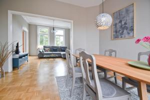 een eetkamer en een woonkamer met een tafel en stoelen bij Stadtvilla Stöhr in Norden