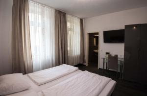 - une chambre avec un lit et une grande fenêtre dans l'établissement Hotel Luisenhof, à Wiesbaden