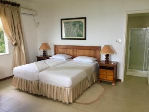 a bedroom with a large bed and two night stands at Beau Séjour Hotel in Victoria