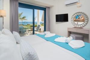 una camera con letto e vista sull'oceano di Pyrgos Beach Hotel Apartments a Mália