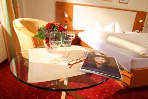 een kamer met een tafel met glazen en een bed bij Landhotel Salmen in Oberkirch