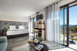 um quarto com uma cama e uma grande janela em Hotel & Spa des Gorges du Verdon em La Palud sur Verdon