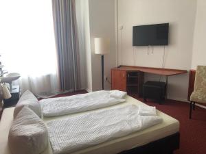 um quarto de hotel com duas camas e uma televisão em Hotel-Pension Adamshof em Berlim