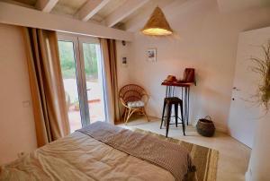 1 dormitorio con cama, ventana y mesa en La Casa Menorca, en Ferreries