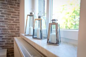 a row of three mirrors sitting on a counter with a window at Apartament Kalinka in Nysa