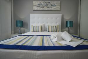 a bedroom with a large bed with two lamps at Holidays Nazaré marginal in Nazaré