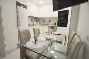 a kitchen with a glass dining table and chairs at Holidays Nazaré marginal in Nazaré