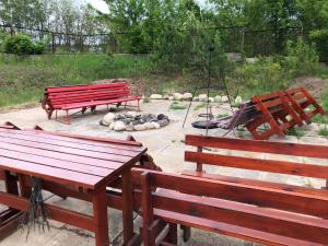 zwei rote Bänke und eine Schaukel im Park in der Unterkunft Stacja Wypoczynkowa Augustów in Augustów