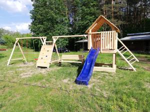 einen Spielplatz mit zwei Schaukeln und einer Rutsche in der Unterkunft Stacja Wypoczynkowa Augustów in Augustów