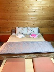 een bed in een houten kamer met twee handdoeken erop bij Villa ORKA Pelister - Forest Zone in Bitola