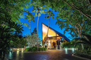 uma casa no meio de uma floresta com palmeiras em Niramaya Villas and Spa em Port Douglas