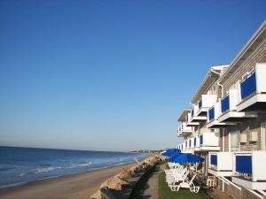 budynek na plaży z leżakami i parasolami w obiekcie Pleasant View Inn w mieście Westerly