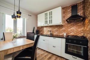 cocina con mesa y pared de ladrillo en Apartament Nadmorski, en Gdynia