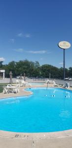 une grande piscine bleue avec des tables et des chaises dans l'établissement Heritage Hotel Lancaster, à Lancaster