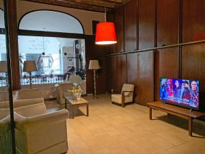 un salon avec une télévision à écran plat sur une table dans l'établissement Hotel Sussex, à Córdoba