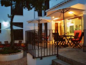 d'une terrasse avec des chaises, des tables et des parasols. dans l'établissement La Posada de Quijada, à Grenade