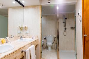 La salle de bains est pourvue de toilettes, d'un lavabo et d'une douche. dans l'établissement Peñiscola Plaza Suites, à Peñíscola