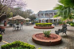 un patio con bancos, mesas y sillas y un edificio en Maison Saint Charles, en Nueva Orleans