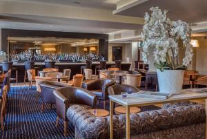 un ristorante con tavoli, sedie e fiori di Hotel Colessio a Stirling