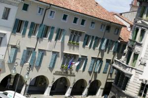 ein großes Gebäude mit blauen Rollläden auf einer Straße in der Unterkunft Astoria Hotel Italia in Udine