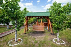 un gazebo in legno in un parco con due alberi di Magic Garden by Vlăduț a Bacău