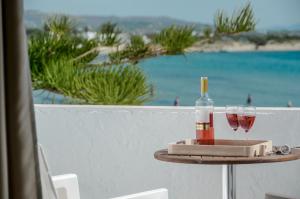 einen Tisch mit einer Flasche und zwei Gläsern Wein in der Unterkunft Prestige on the beach in Naxos Chora