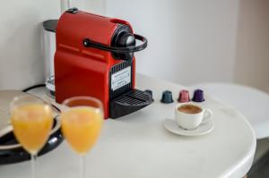 eine Kaffeemaschine und 2 Gläser Orangensaft in der Unterkunft Prestige on the beach in Naxos Chora