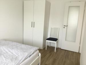 een slaapkamer met een bed, een stoel en een spiegel bij Ferienhaus Am Yachthafen in Rendsburg