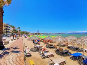 a beach with chairs and umbrellas and the ocean at Mare Civitas Apartments in Chania Town