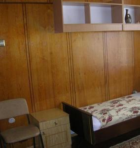 um pequeno quarto com uma cama e uma cadeira em Pilligrim em Carcóvia