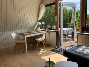 a living room with a desk and a table and chairs at Ferienhaus nähe Warnemünde in Elmenhorst